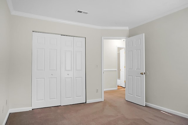 unfurnished bedroom featuring ornamental molding, a closet, and light carpet