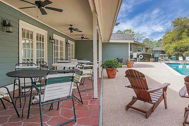 view of patio featuring a community pool, french doors, and ceiling fan