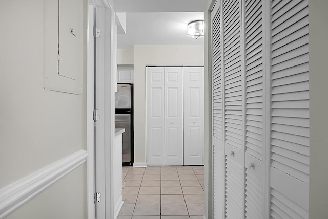 hallway with electric panel and light tile patterned floors