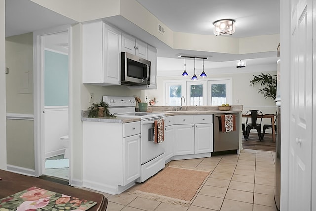 kitchen featuring pendant lighting, sink, white cabinets, stainless steel appliances, and light tile patterned floors