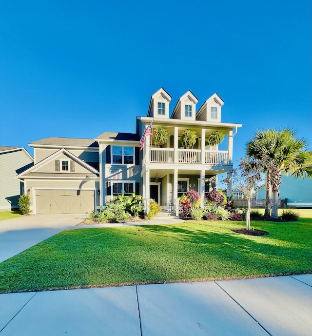 view of front facade featuring a balcony, a front yard, and a garage