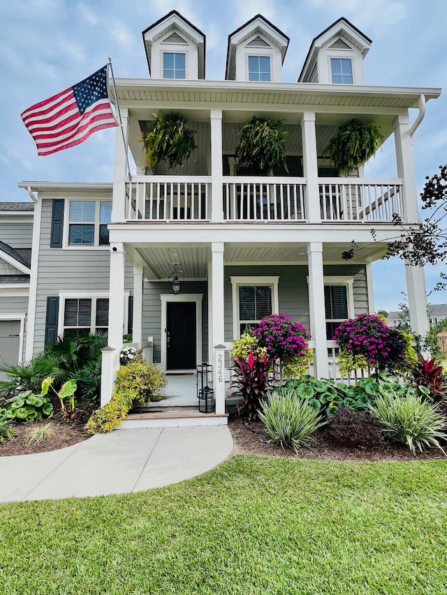 view of front of home with a balcony and a front lawn