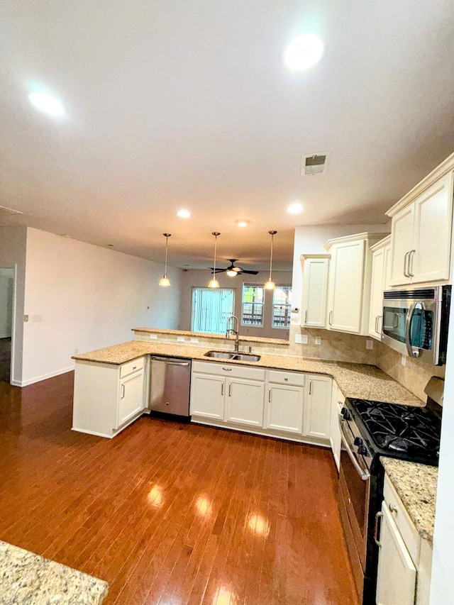 332 Southern Sugar Ave, Moncks Corner, SC 29461 - kitchen featuring stainless steel appliances, a sink, a peninsula, dark wood-type flooring, and white cabinetry