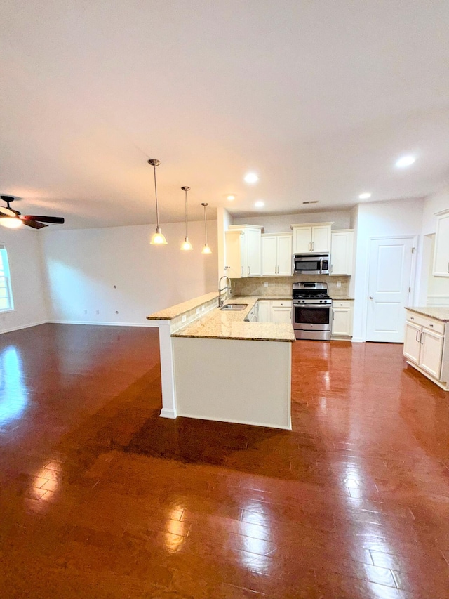 332 Southern Sugar Ave, Moncks Corner, SC 29461 - kitchen featuring stainless steel appliances, a sink, a peninsula, ceiling fan, and hanging light fixtures
