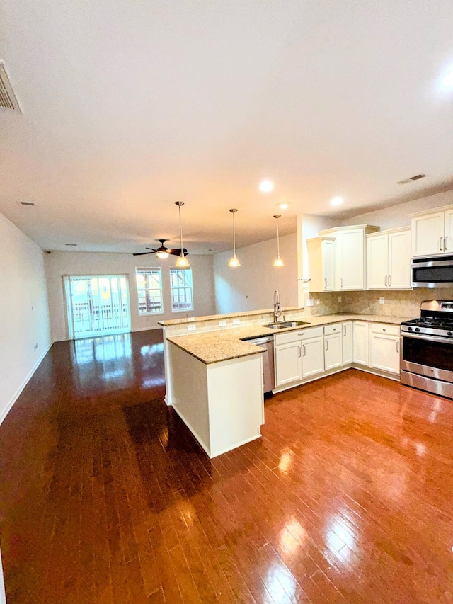 332 Southern Sugar Ave, Moncks Corner, SC 29461 - kitchen with appliances with stainless steel finishes, open floor plan, a peninsula, a sink, and hardwood / wood-style flooring