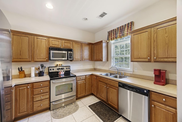 kitchen featuring light tile patterned floors, sink, and stainless steel appliances