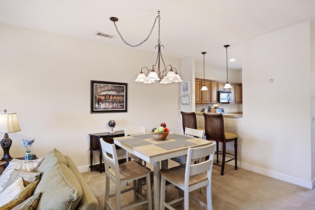 carpeted dining area featuring a chandelier