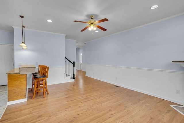 living room featuring crown molding, light hardwood / wood-style flooring, and ceiling fan