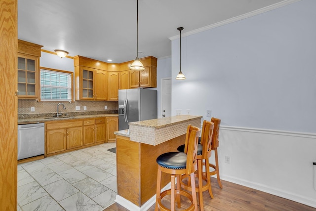 kitchen featuring sink, a breakfast bar area, hanging light fixtures, stainless steel appliances, and kitchen peninsula