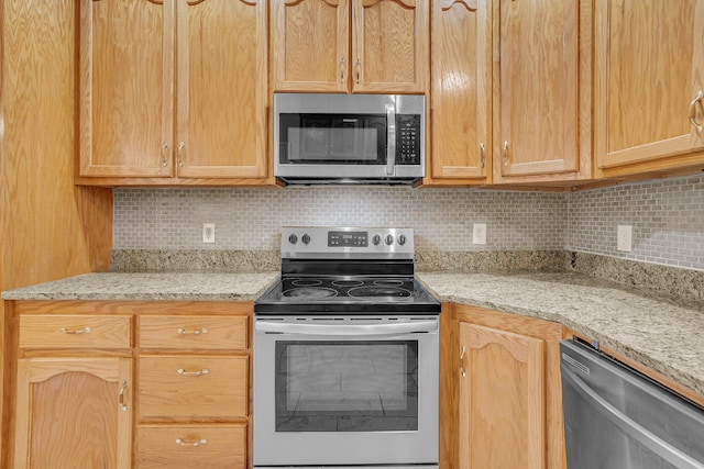 kitchen featuring light stone counters, appliances with stainless steel finishes, light brown cabinets, and backsplash