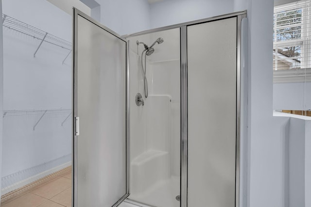 bathroom featuring tile patterned floors and a shower with shower door