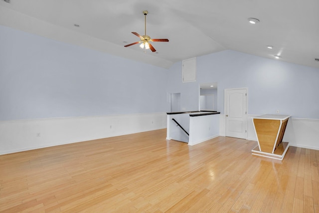 unfurnished living room with ceiling fan, lofted ceiling, and light wood-type flooring