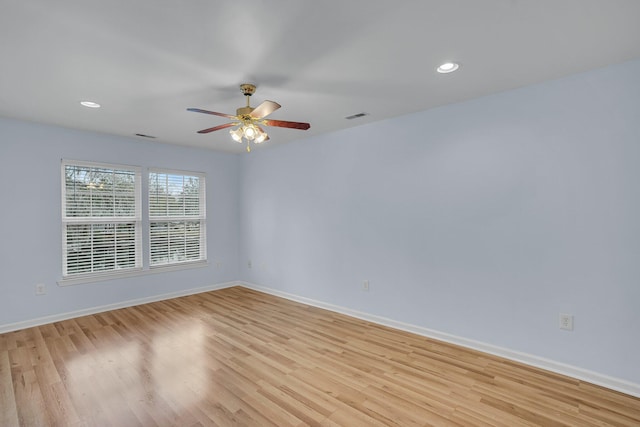 empty room with ceiling fan and light hardwood / wood-style flooring