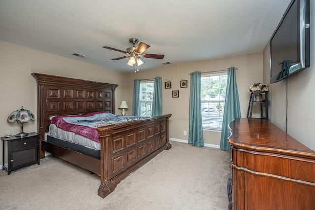 bedroom with baseboards, multiple windows, visible vents, and light colored carpet