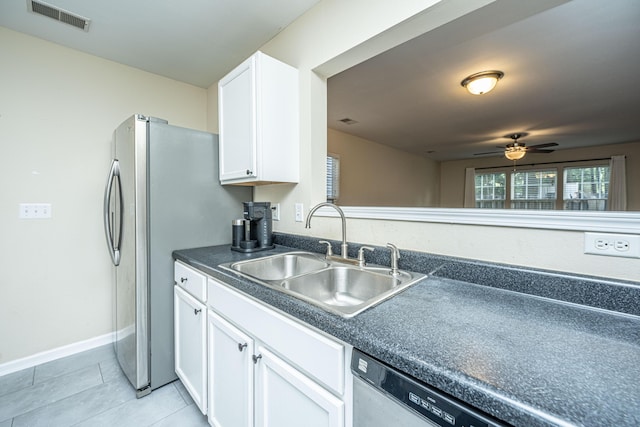 kitchen with light tile patterned floors, a sink, visible vents, white cabinetry, and dark countertops