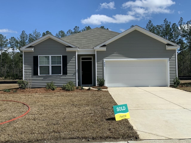 single story home with concrete driveway and an attached garage