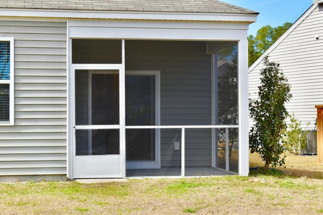 back of house with a lawn and a sunroom