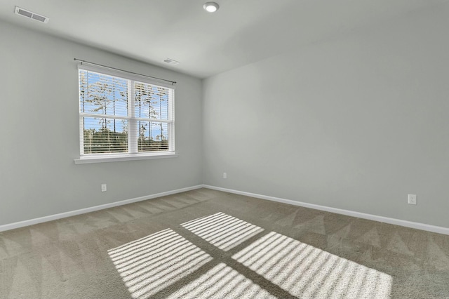 unfurnished room with visible vents, baseboards, and carpet flooring