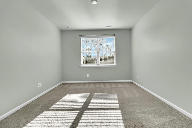 spare room featuring visible vents, baseboards, and carpet floors