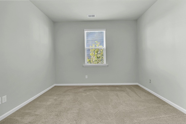 carpeted spare room featuring baseboards and visible vents