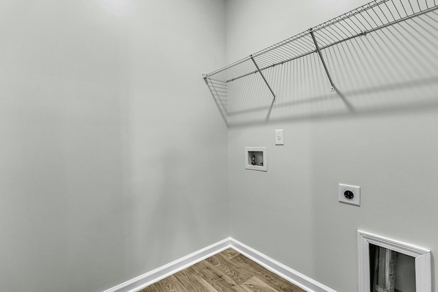 laundry area featuring washer hookup, wood finished floors, baseboards, hookup for an electric dryer, and laundry area