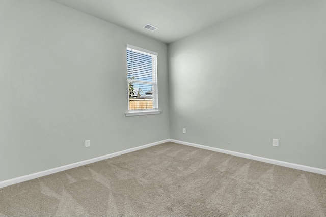 empty room featuring visible vents, baseboards, and carpet