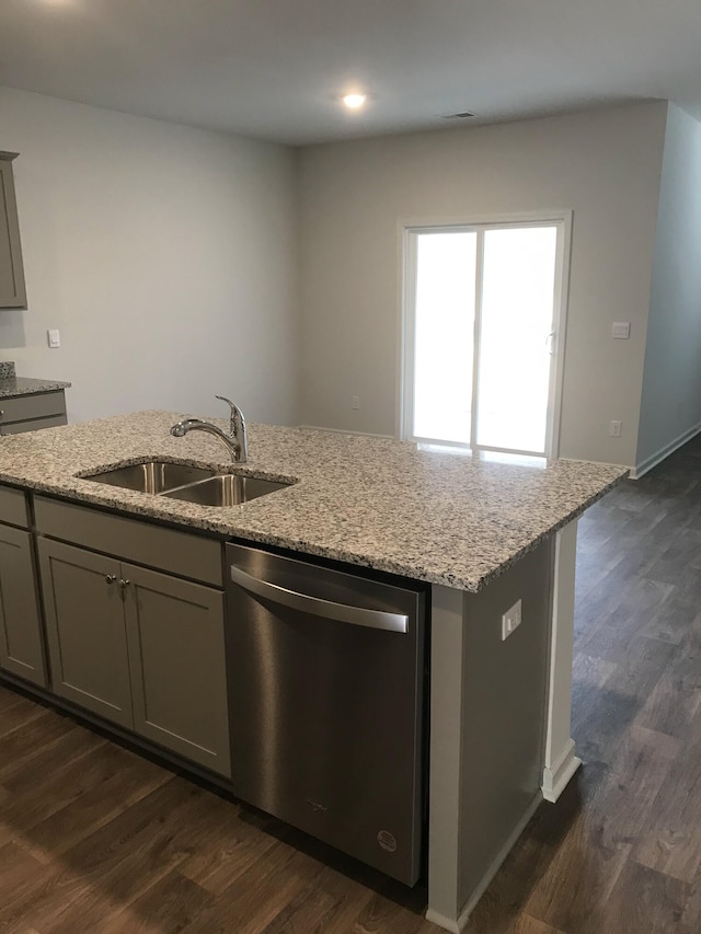 kitchen featuring gray cabinetry, dark wood-type flooring, dishwasher, light stone counters, and a sink