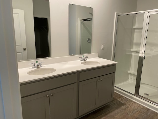 full bath with wood finished floors, a stall shower, and a sink