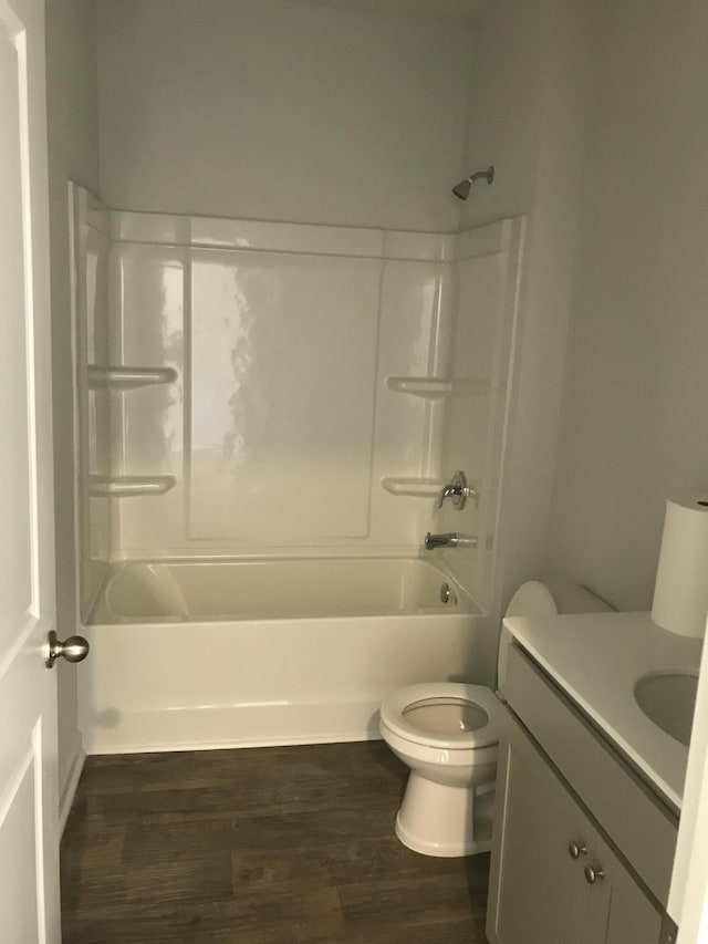 bathroom with shower / bath combination, toilet, wood finished floors, and vanity