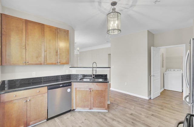 kitchen featuring light hardwood / wood-style floors, washer / dryer, sink, and appliances with stainless steel finishes