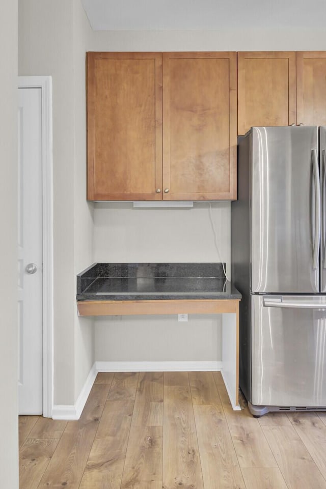 kitchen with stainless steel fridge and light hardwood / wood-style flooring