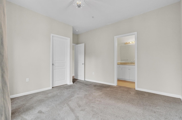 unfurnished bedroom with ensuite bathroom and light colored carpet