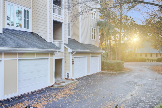 view of side of home featuring a balcony and a garage