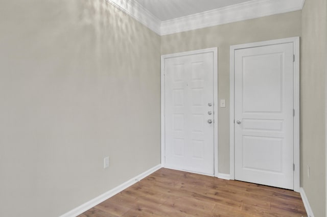 entrance foyer with ornamental molding and hardwood / wood-style flooring