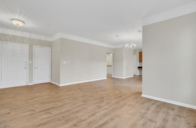 empty room with ornamental molding, light hardwood / wood-style floors, and an inviting chandelier