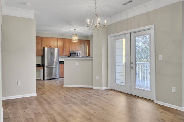 kitchen with hanging light fixtures, french doors, stainless steel appliances, and light wood-type flooring