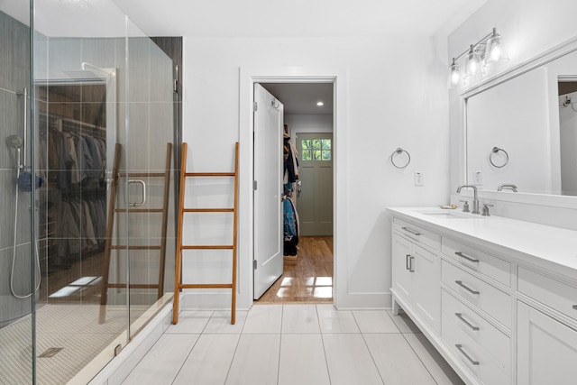 bathroom featuring hardwood / wood-style floors, vanity, and a shower with shower door