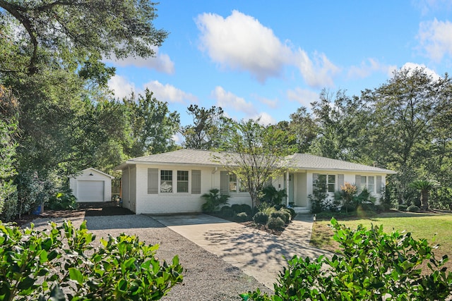 single story home featuring a garage, an outbuilding, and a front yard