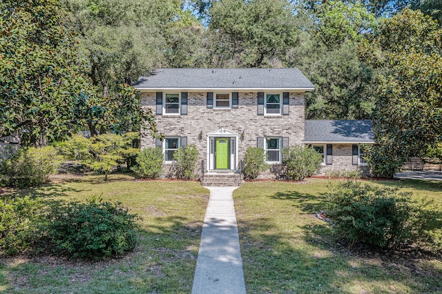 colonial-style house featuring a front yard