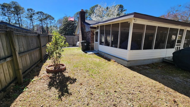 view of yard featuring a fenced backyard and a sunroom