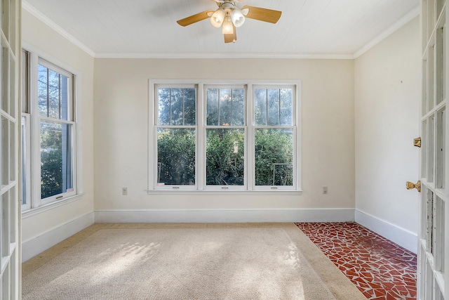 carpeted spare room with ornamental molding, a wealth of natural light, and ceiling fan