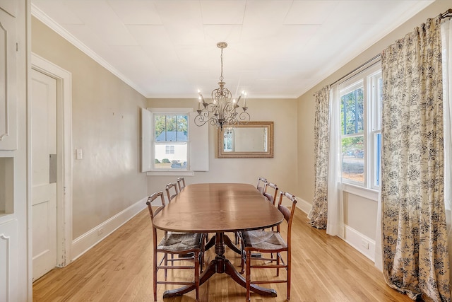 dining room featuring an inviting chandelier, light wood-type flooring, and ornamental molding