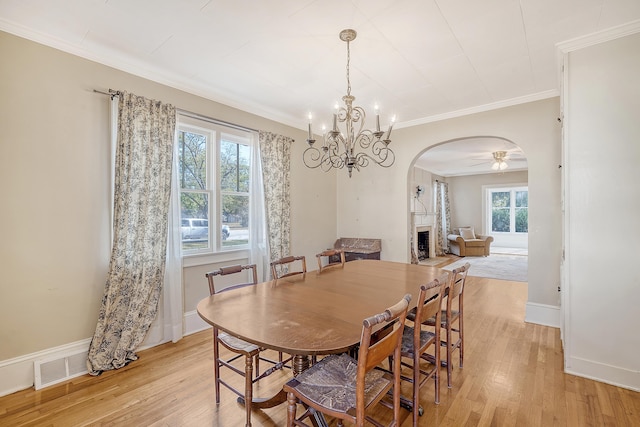 dining area featuring ceiling fan with notable chandelier, crown molding, and light hardwood / wood-style flooring