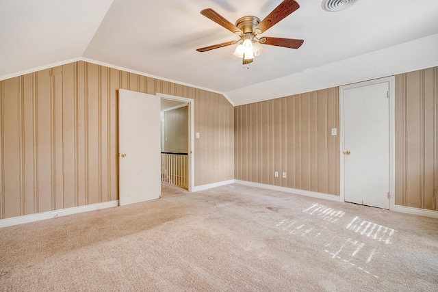 spare room featuring light carpet, ceiling fan, and vaulted ceiling