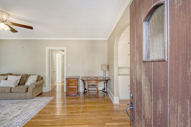 living room with light hardwood / wood-style floors, ceiling fan, and ornamental molding