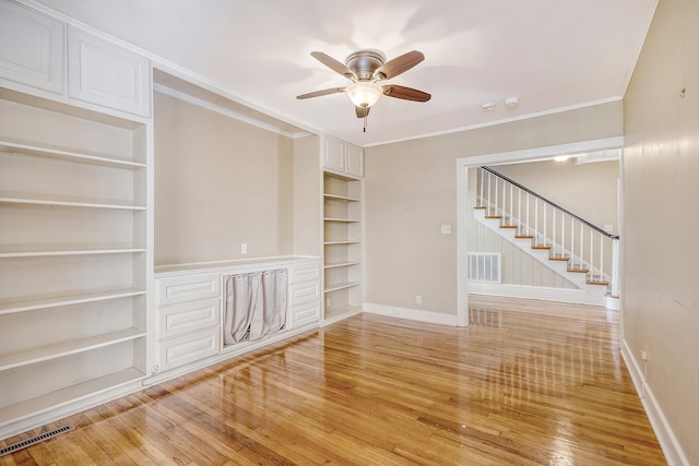 unfurnished living room featuring ornamental molding, light hardwood / wood-style flooring, built in shelves, and ceiling fan