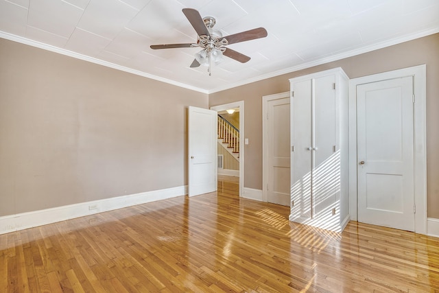 unfurnished room with crown molding, ceiling fan, and light hardwood / wood-style flooring