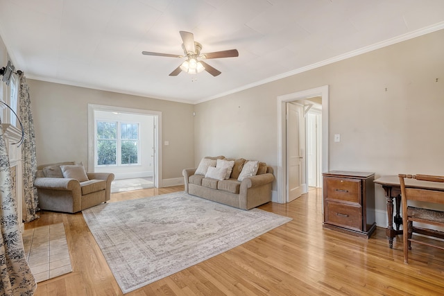 living room with ornamental molding, light hardwood / wood-style floors, and ceiling fan