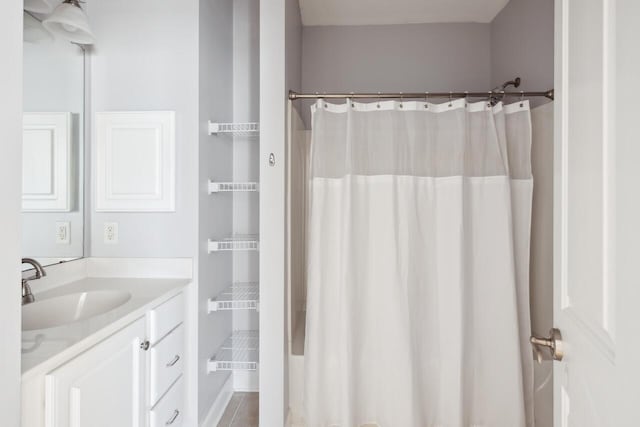 bathroom with tile patterned flooring, vanity, and walk in shower