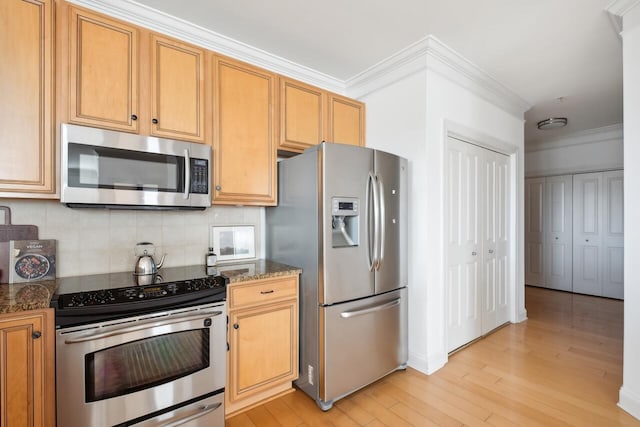 kitchen featuring stainless steel appliances, dark stone counters, decorative backsplash, light hardwood / wood-style floors, and ornamental molding